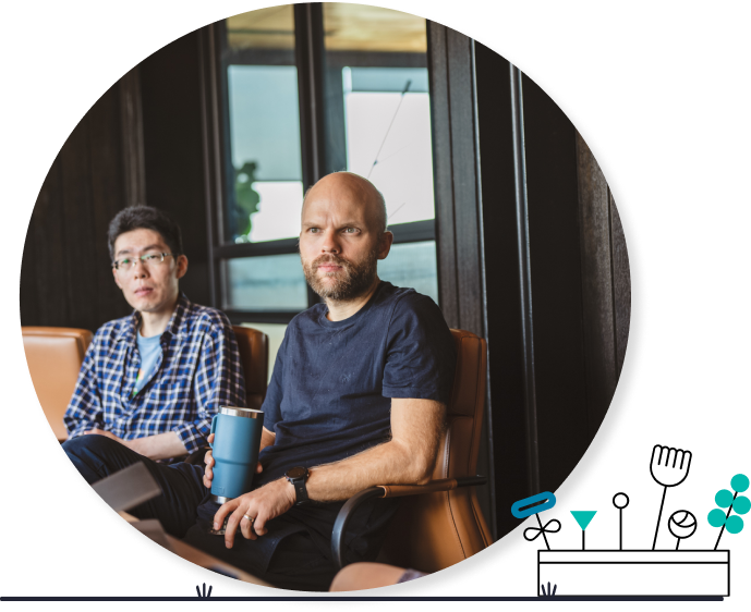 Image of two men sitting at a table in brown chairs